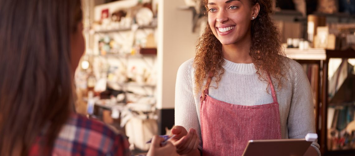 Sales Assistant With Credit Card Reader On Digital Tablet